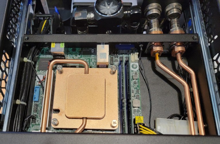 Direct liquid cooling hardware with a copper cold plate and coolant tubing inside a computer system