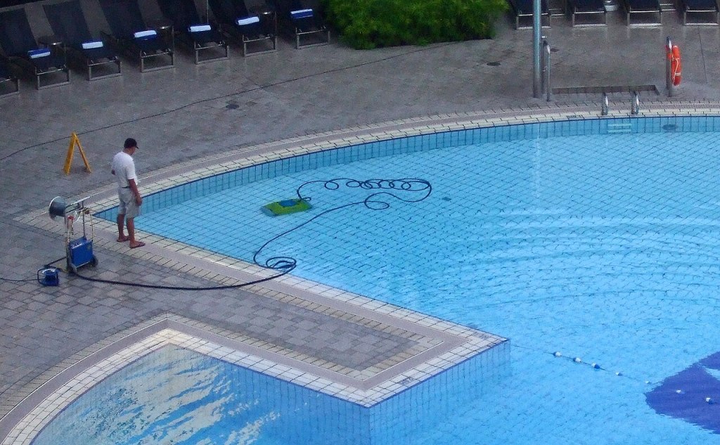 A robotic pool cleaner operating underwater in a swimming pool