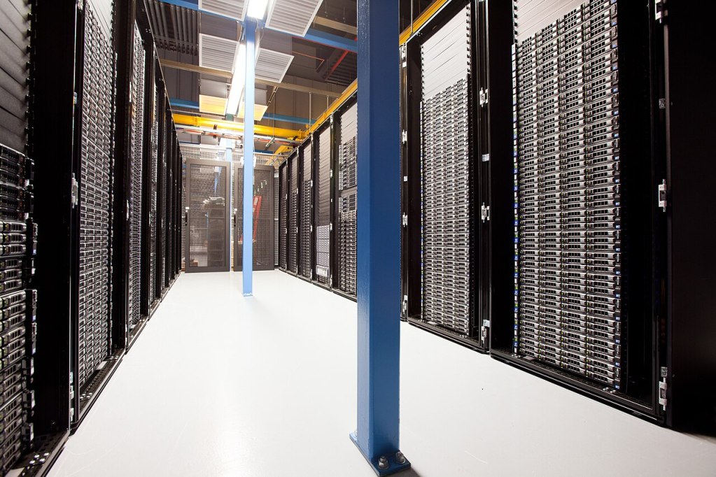Rows of server racks inside a data center aisle