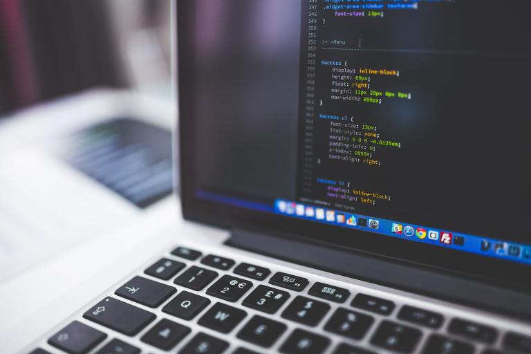 Laptop displaying programming code on screen