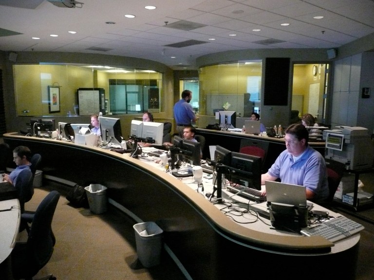 Network operations center with monitoring screens and operator workstations