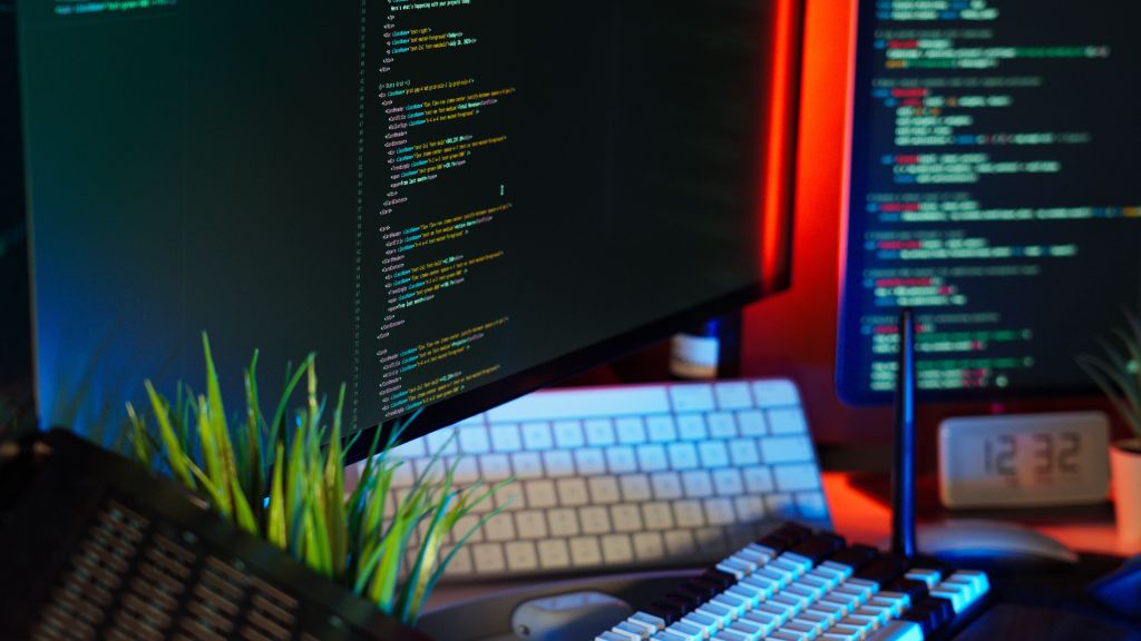 Modern workspace with multiple coding screens and a keyboard